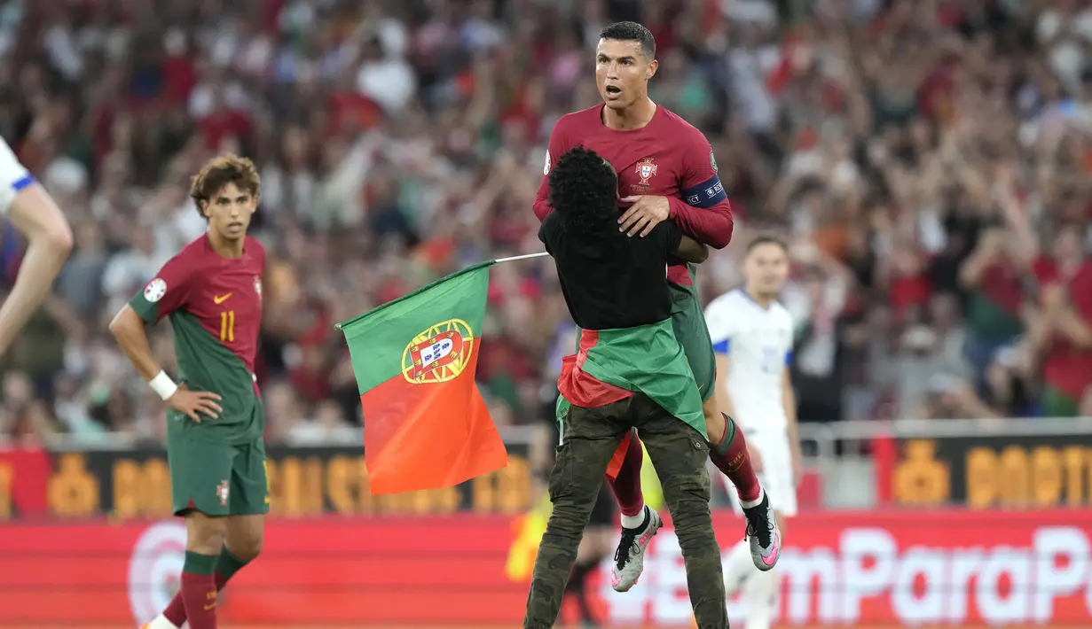 Seorang suporter mengangkat tubuh Cristiano Ronaldo dalam laga Grup J Kualifikasi Euro 2024 antara Portugal dan Bosnia-Herzegovina di Estadio da Luz, Lisbon, Minggu (18/6/2023) dini hari WIB.  (AP Photo/Armando Franca)