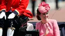 Kate Middleton menaiki kereta kuda saat parade Trooping the Color di London, Inggris, Sabtu (17/6). Gaya Kate Middleton semakin sempurna berkat topi berwarna pink yang dipercantik dengan dekorasi lipit yang unik. (AP Photo/Kirsty Wigglesworth)