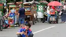 Pedagang kaki lima menjajakan makanan dan minuman di sisi jalan sekitar kawasan Patung Kuda Jakarta, Rabu (5/1/2019). Mereka mencoba peruntungan saat para buruh melakukan aksi perayaan Hari Buruh International atau May Day. (Liputan6.com/Helmi Fithriansyah)