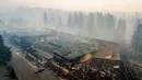 Asap mengepul usai kebakaran menghanguskan Old Town Plaza di Kota Paradise, California, AS, Kamis (15/11). Kebakaran telah menewaskan 48 orang dan lebih dari 100 lainnya masih belum ditemukan. (AP Photo/Noah Berger)
