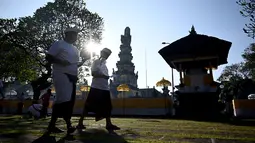 Umat ​​Hindu berjalan menuju Pura Jagat Natha untuk merayakan hari raya Galungan di Denpasar, Bali, Rabu (8/6/2022).  Hari Raya Galungan dan Kuningan merupakan hari besar suci umat Hindu yang jatuh setiap enam bulan sekali. (SONNY TUMBELAKA / AFP)