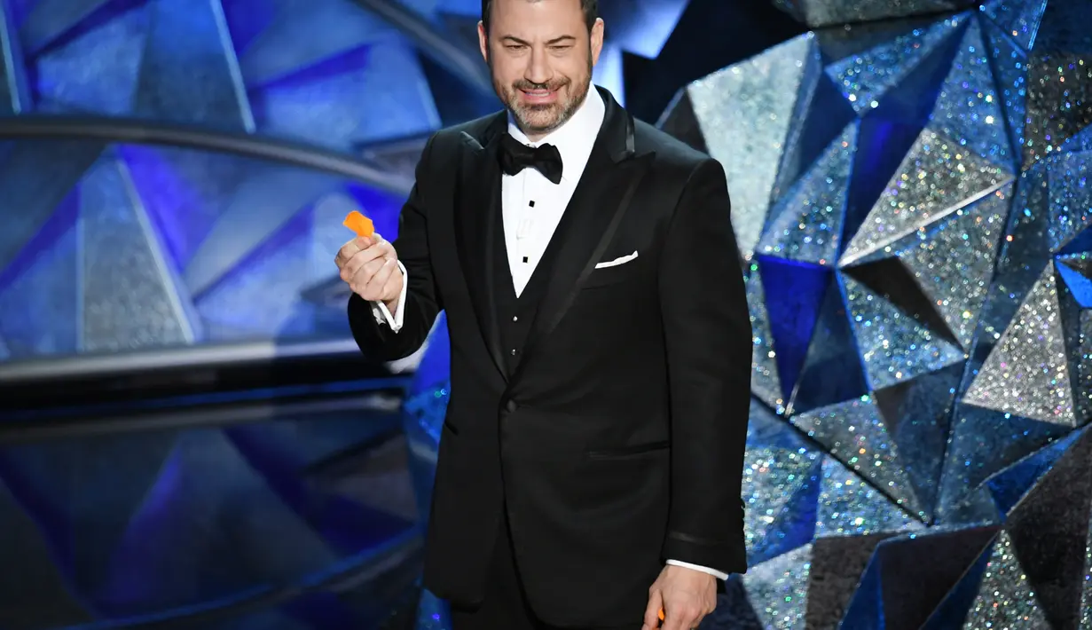 "Tahun ini, saat kamu mendengar namamu disebut, jangan langsung berdiri," ujar Jimmy Kimmel. "Beri kamu waktu satu menit," sambungnya yang disambut riuh tawa penonton. (KEVIN WINTER / GETTY IMAGES NORTH AMERICA / AFP)