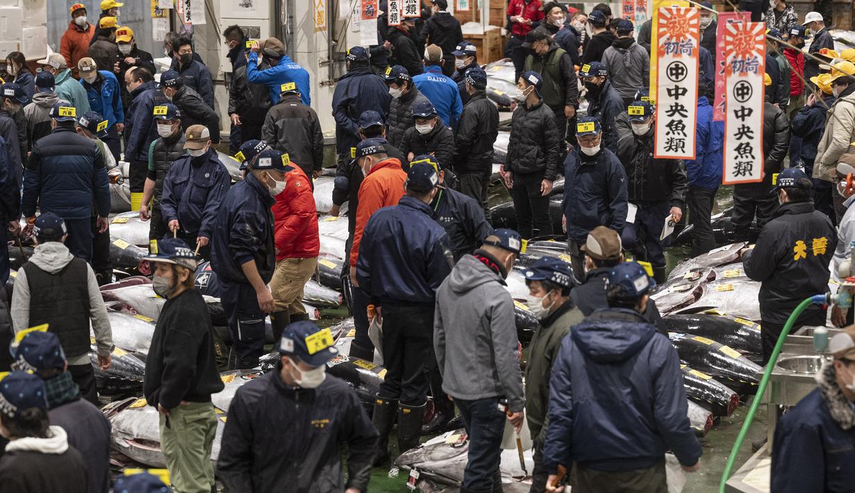 Penjual dan pembeli grosir menghadiri lelang tuna pertama Tahun Baru di pasar ikan Toyosu di Tokyo (5/1/2023). Pada tahun ini, lelang tuna tertinggi terjual lebih dari USD 270.000. Hampir dua kali lipat dari harga tahun lalu. (AFP/Richard A. Brooks)