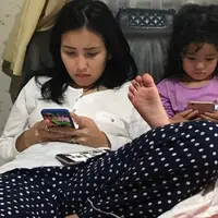 Ayu Ting Ting dan Bilqis sedang asyik melihat sesuatu di telepon genggamnya (Instagram/@mom_ayting92_)