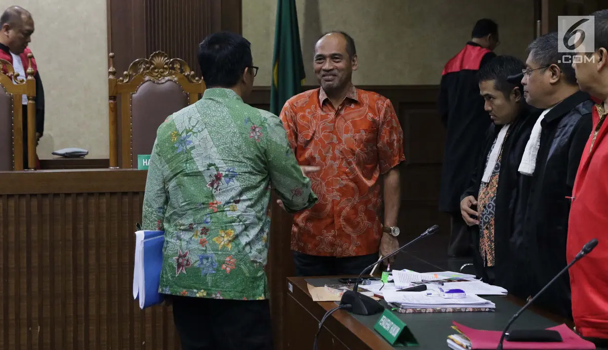 Menpora Imam Nahrawi (batik hijau) menyalami Deputi IV Bidang Peningkatan Prestasi Kemenpora, Mulyana saat jeda sidang lanjutan suap dana hibah untuk KONI dengan terdakwa Mulyana serta Adhi Purnomo dan Eko Triyanta di Pengadilan Tipikor, Jakarta, Kamis (4/7/2019). (Liputan6.com/Helmi Fithriansyah)