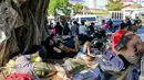 Pihak KBRI di Phnom Penh menyatakan permasalahan utama dari para WNI adalah tidak memegang paspor dan menetap di Kamboja tanpa perizinan keimigrasian yang valid. Tampak dalam foto, orang-orang berkumpul di depan Kedutaan Besar Republik Indonesia (KBRI) di Phnom Penh, Kamboja, pada Rabu 21 Januari 2026. (TANG CHHIN Sothy/AFP)