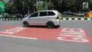 Mobil melintas di samping jalur khusus kontingen Asian Games 2018  di Jalan Benyamin Sueb, Kemayoran, Jakarta, Senin (30/4). Pemprov DKI menyediakan jalur khusus menyambut kontingen Asian Games pada Agustus mendatang. (Liputan6.com/Arya Manggala)