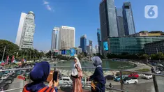 Sejumlah orang berswafoto di anjungan Transjakarta kawasan Bundaran HI, Jakarta, Selasa (1/8/2023). Menurut Badan Meteorologi, Klimatologi, dan Geofisika (BMKG) suhu udara akan berkisar 22 hingga 34 derajat Celcius di siang hari, dengan kelembaban 50-80 persen. (Liputan6.com/Faizal Fanani)