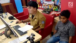 Petugas Disdukcapil Kota Tangerang Selatan melakukan pembuatan Kartu Identitas Anak (KIA) di tempat makan siap saji kawasan Bintaro Tangerang Selatan, Selasa (26/2). (Merdeka.com/Arie Basuki)