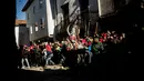 Orang-orang melempari seorang pria berkostum ala setan dengan sayuran lobak selama Festival Jarramplas di kota Piornal, Spanyol, Sabtu (19/1). Meski berlangsung selama berabad-abad namun tidak diketahui pasti asal muasal festival ini. (AP/Javier Fergo)