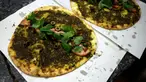 Roti pipih tradisional Lebanon, manoushe dengan taburan mint, tomat, dan zaitun dipajang di konter toko roti di Tabarja, Beirut, Lebanon, 6 Desember 2023. Badan Kebudayaan PBB pada 6 Desember mengatakan pihaknya menambahkan manoushe ikonik Lebanon ke dalam daftar warisan budaya tak benda. (JOSEPH EID/AFP)