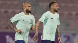 Penyerang Brasil Neymar dan rekan setimnya Dani Alves menghadiri sesi latihan jelang menghadapi Timnas Serbia di stadion Grand Hamad, di Doha, Qatar, Rabu (23/11/2022). Tim Samba konon akan tampil habis-habisan di lini serang demi memetik kemenangan pertama di ajang Piala Dunia 2022 . (AP Photo/Andre Penner)