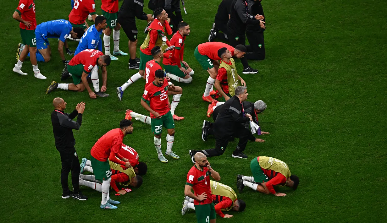 Para pemain Maroko tetap bersujud syukur usai pertandingan melawan Prancis pada semifinal Piala Dunia 2022 di Stadion Al-Bayt di Al Khor, Doha, Kamis (15/12/2022). Maroko kalah dari Prancis 2-0 dan gagal melaju ke final Piala Dunia 2022. (AFP/Anne-Christine POUJOULAT)
