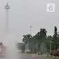 Petugas pemadam kebarakan menyemprotkan cairan disinfektan di kompleks Monumen Nasional (Monas), Jakarta, Senin (30/3/2020). Penyemprotan disinfektan ini dilakukan guna memutus rantai penyebaran virus Corona atau Covid-19 di pusat kota. (merdeka.com/Iqbal S. Nugroho)