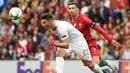 Penyerang Portugal, Cristiano Ronaldo, berebut bola dengan bek Swiss, Fabian Schar, pada laga UEFA Nations League di Estadio Do Dragao, Porto, Kamis (6/6) dini hari WIB. Portugal menang 3-1 atas Swiss. (AFP/Miguel Riopa).
