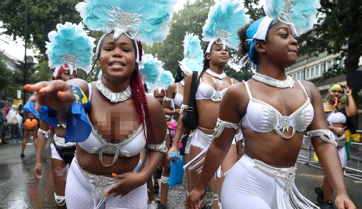 Penari karnaval menari selama parade hari pertama Karnaval Notting Hill di London barat, Minggu (26/8). Warga Liverpool sampai Birmingham bahkan tak sedikit yang pergi ke London setahun sekali ikut menikmati pesta. (AFP/Daniel LEAL-OLIVAS)
