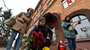 Seorang wanita menaruh bunga di depan Kedutaan Besar Prancis di Minsk Sabtu (14/11/2015) . Karangan bunga tersebut untuk menghormati para korban serangan mematikan di Paris. (AFP Photo/Maxim Malinovsky)