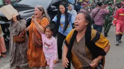 Diduga masih terdapat 38 orang yang masih terjebak dalam reruntuhan. Tampak dalam foto, beberapa perempuan bereaksi saat mereka menjauh setelah bangunan runtuh di sebuah pesantren di Sidoarjo, Jawa Timur, Selasa 30 September 2025. (AP Photo/Trisnadi)