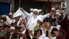 Rizieq Shihab menyapa massa pendukungnya saat tiba di kediamannya di Jalan Petamburan, Jakarta, Selasa (10/11/2020). Rizieq Shihab tiba di kediamannya usai pulang dari Arab Saudi. (merdeka.com/Imam Buhori)