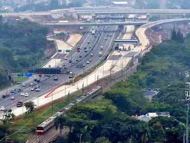 Sejumlah kendaraan melintas di dekat proyek pembangunan tol yang merupakan bagian dari Tol JORR II di kawasan BSD, Tangerang Selatan, Banten, Minggu (15/12). Jalan tol ini nantinya menyambungkan Tol Kunciran–Serpong di bagian barat dan Tol Cinere–Jagorawi di bagian timur. (merdeka.com/Arie Basuki)