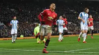 Striker Manchester United Alexis Sanchez merayakan gol kedua untuk timnya saat melawan Huddersfield Town dalam pertandingan Liga Inggris di Old Trafford di Manchester (3/2). (AFP Photo/Paul Ellis)