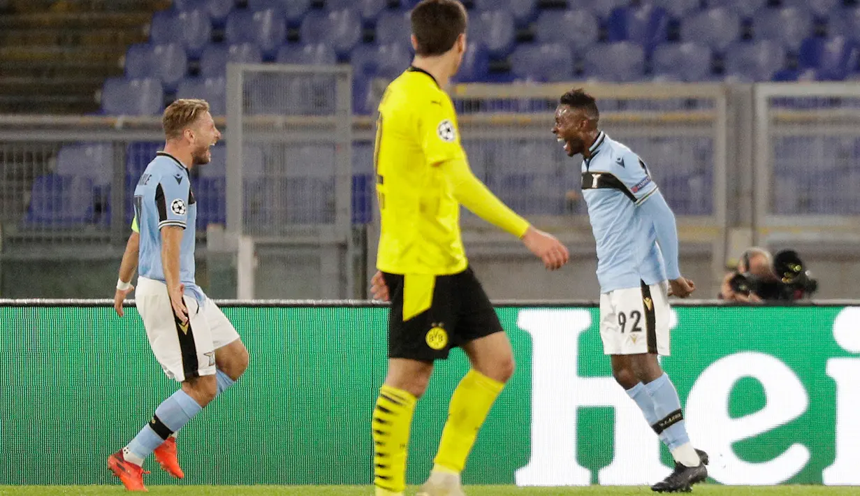 Gelandang Lazio, Jean-Daniel Akpa Akpro merayakan dengan rekan setimnya, Ciro Immobile setelah mencetak gol ke gawang wakil Bundesliga, Borussia Dortmund pada pertandingan perdana Grup F Liga Champions 2020 di Stadion Olimpico, Rabu (21/10/2020) dini hari WIB. Lazio menang 3-1 atas Borussia Dortmund