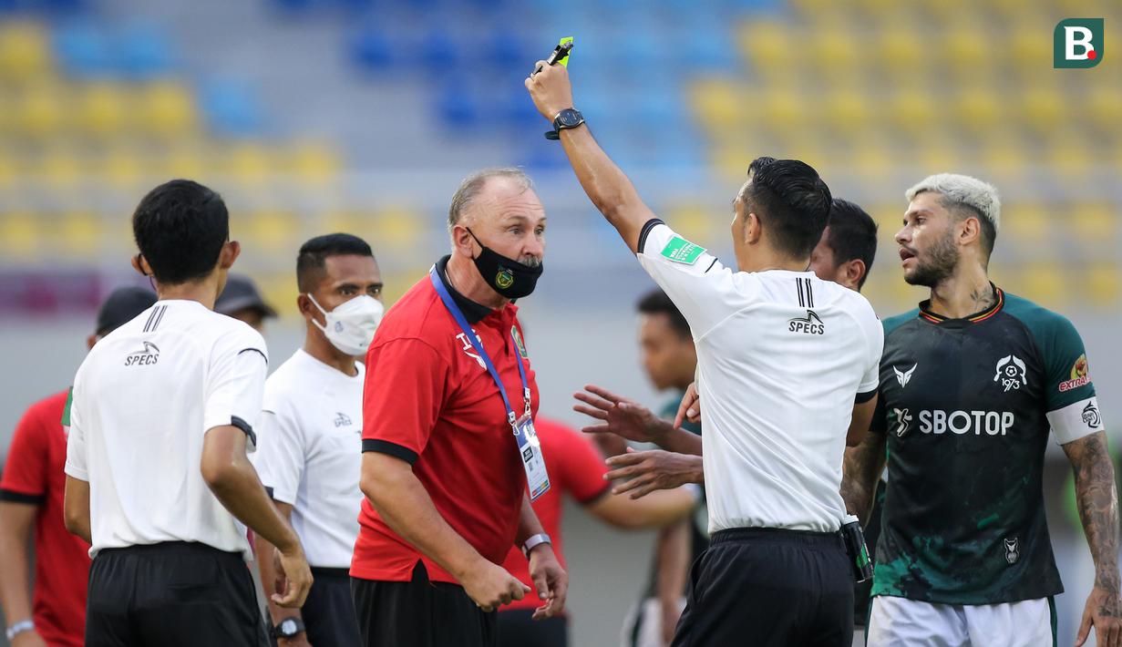 Pelatih Persikabo 1973, Ihar Kryushenko (tengah) mendapatkan kartu kuning dari wasit Fariq Hitaba saat melawan PSIS Semarang dalam laga pekan ke-12 BRI Liga 1 2021/2022 di Stadion Manahan, Solo, Kamis (18/11/2021). (Bola.com/Bagaskara Lazuardi)