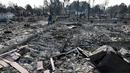 Phil Rush berjalan di puing-puing rumahnya yang rata dengan tanah setelah kebakaran hebat di kawasan penghasil anggur Santa Rosa, California, Rabu (11/10). Setidaknya 17 orang tewas dan sekitar 2.000 bangunan hancur total dimakan api. (AP Photo/Jeff Chiu)