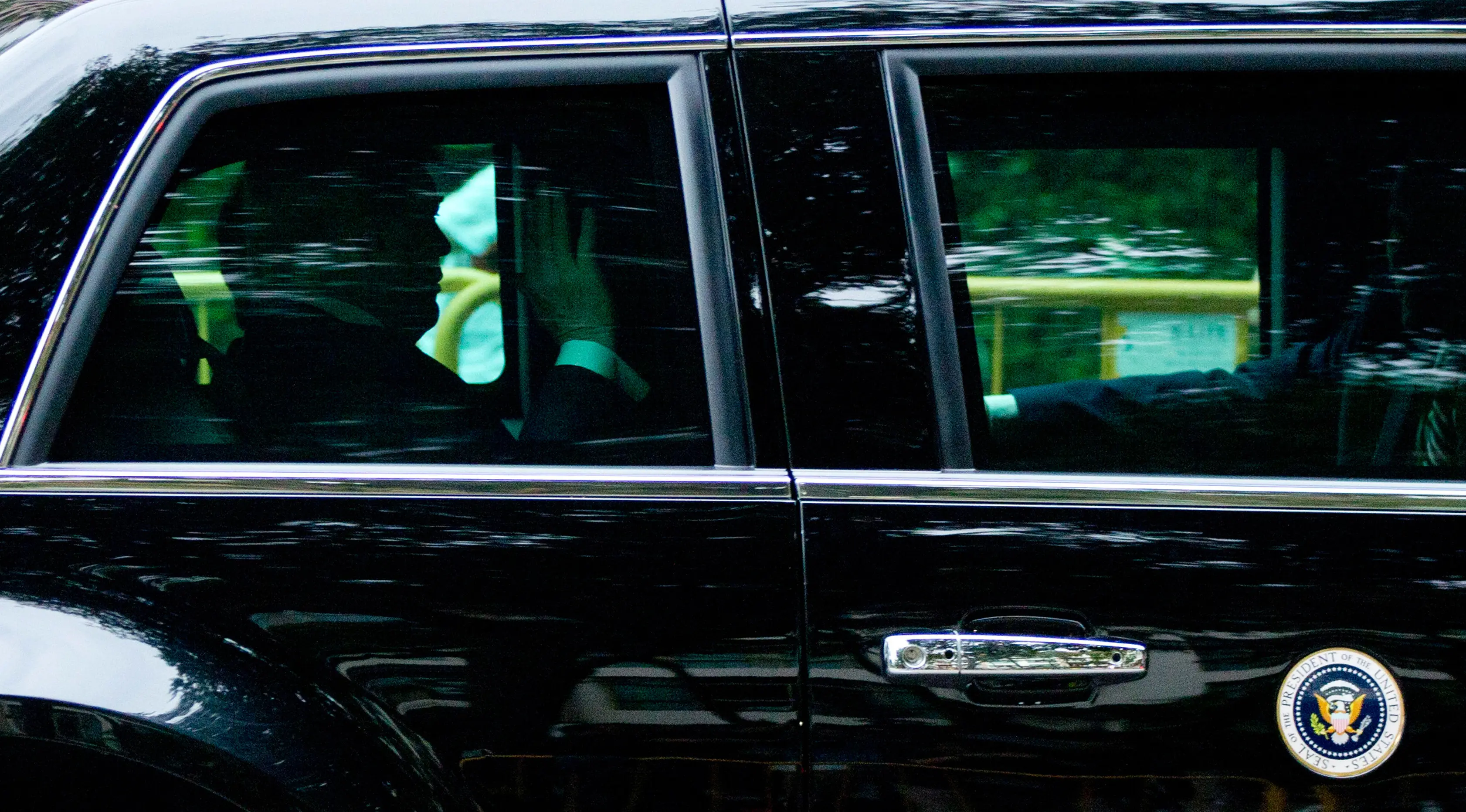 Presiden AS Donald Trump melambaikan tangan ketika mobilnya meninggalkan hotel Shangri-La, Singapura, Selasa (12/6). Trump dan pemimpin Korea Utara, Kim Jong-un akan bertemu dalam KTT Korea Utara-AS di Hotel Capella, Pulau Sentosa. (AP/Gemunu Amarasinghe)