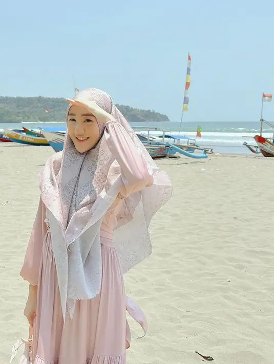 Ibu satu anak ini memadukan gamis dengan kerudung motif warna pastel, serasi dengan outfitnya. [@larissachou]