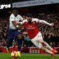 Bek sayap Arsenal, Sead Kolasinac berduel dengan pemain Tottenham hotspur, Serge Aurier dalam laga lanjutan Liga Inggris pekan ke-14 yang berlangsung di stadion Emirates, London, Minggu (2/12). Arsenal menang atas Tottenham Hotspur 2–1. (AFP/Ian Kington)