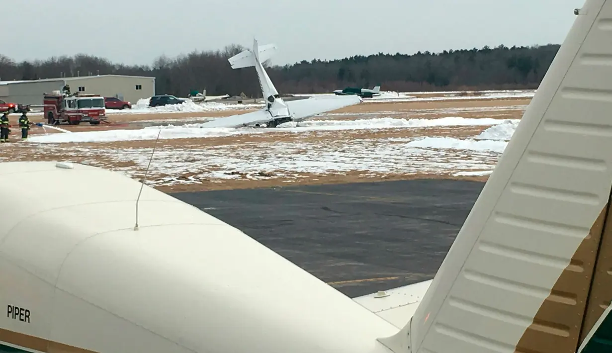 Sebuah pesawat kecil menabrak tanah di Bandara Kota Mansfield, Massachusetts, AS, Sabtu (23/2). Korban tewas kecelakaan merupakan seorang pilot instruktur dan siswanya. (Jared Higginbotham/WBZ-TV, Boston via AP)