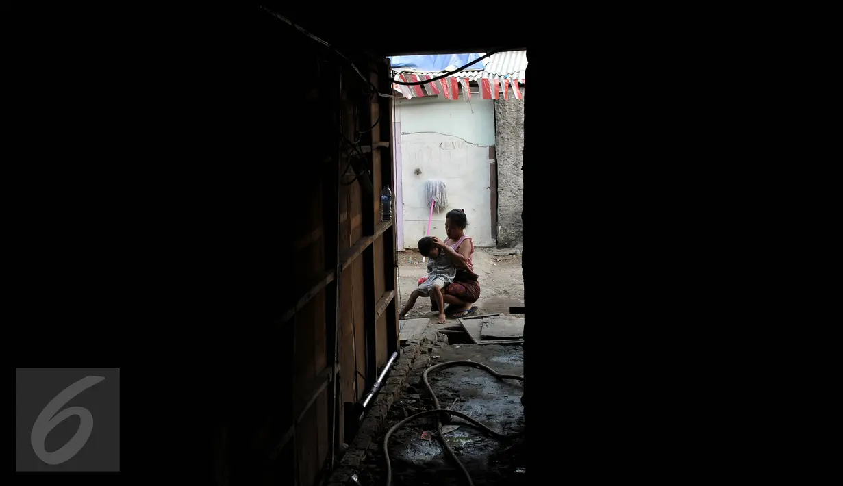 Seorang ibu mencari kutu anaknya di dekat tempat huniannya di kolong jembatan Penjagalan, Penjaringan, Jakarta, Kamis (13/8). Mahalnya biaya hidup dan sewa layak di Jakarta membuat mereka terpaksa tinggal di kolong jembatan. (Liputan6.com/Johan Tallo)