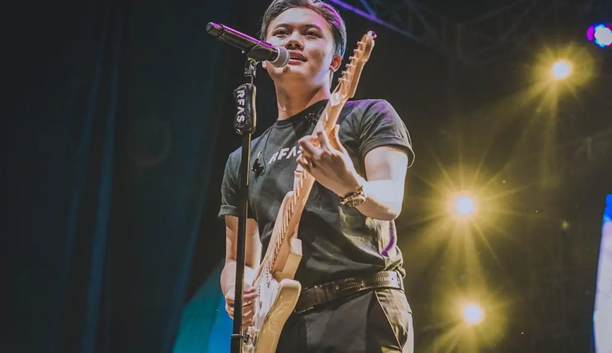 Saat diatas panggung membawakan lagu-lagu hitsnya, Rizky Febian justru menggunakan outift casual dan santai. Meski begitu pesonanya tetap terpancar. Apalagi ketika dirinya mengiringi sendiri lagunya dengan gitar. (Liputan6.com/IG/@rizkyfbian)