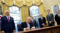 Donald Trump tunjukkan surat perintah eksekutif AS keluar dari TPP di Oval Office pada 23 Januari 2017 (SAUL LOEB / AFP)