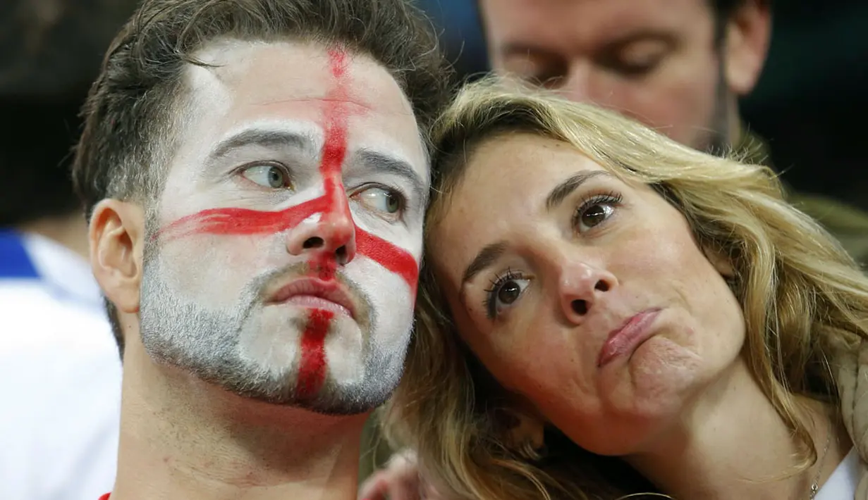 Kesedihan tampak di raut wajah sepasang suporter The Three Lions usai menyaksikan kegagalan Inggris lolos ke fase 16 besar pasca dikalahkan Uruguay 1-2 di Stadion Corinthians, Sao Paulo, Brasil, (20/6/2014). (REUTERS/Laszlo Balogh)