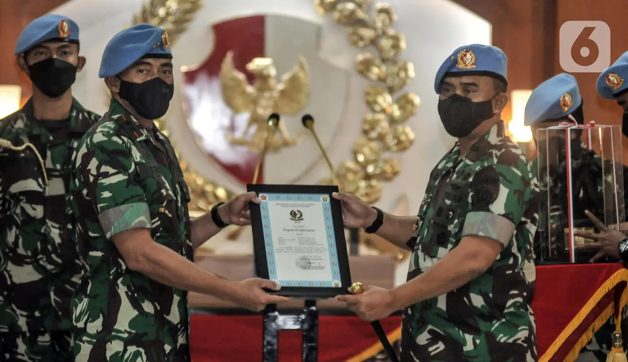 Marsekal Pertama (Marsma) TNI Wahyu Hidayat Sudjatmiko menerima piagam penghgaraan dari Mayjen Tri Budi Utomo saat serah terima jabatan Komandan Pasukan Pengamanan Presiden (Danpaspampres) di Mako Paspampres, Jakarta Pusat, Senin (18/7/2022). Marsma TNI Wahyu Hidayat Sudjatmiko resmi menjabat sebagai Danpaspampres menggantikan Mayjen Tri Budi Utomo. (merdeka.com/Iqbal S. Nugroho)