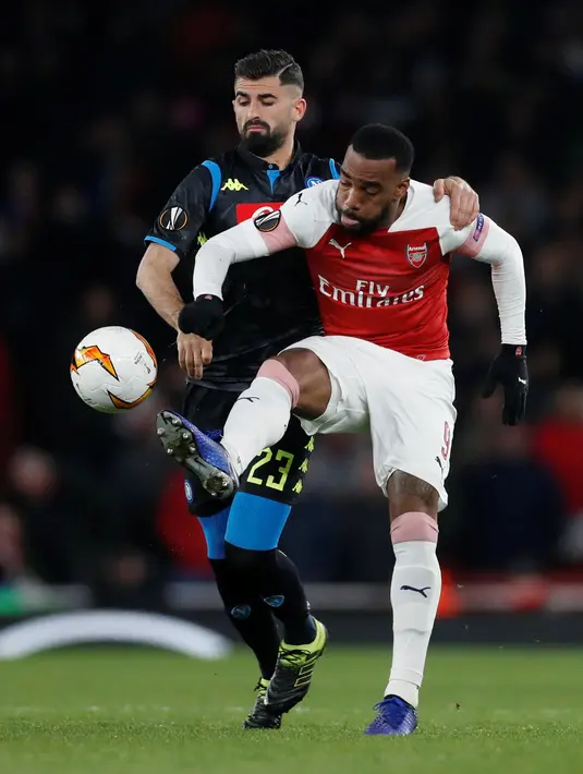 Pemain Napoli, Elseid Hysaj berebut bola dengan  pemain Arsenal, Alexandre Lacazette pada leg pertama perempat final Liga Eropa di Stadion Emirates, Kamis (11/4). Arsenal mendekatkan diri ke semifinal setelah berhasil mengalahkan Napoli 2-0. (Reuters/Matt