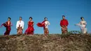 Model dengan balutan busana tradisional berlenggak-lenggok saat fashion show di tanggul Lapindo Porong, Sidoarjo, Jawa Timur, Selasa (13/8/2019). Sebanyak 15 model menunjukkan mode busana yang didominasi warna merah dan putihdalam acara tersebut. (Photo by JUNI KRISWANTO / AFP)