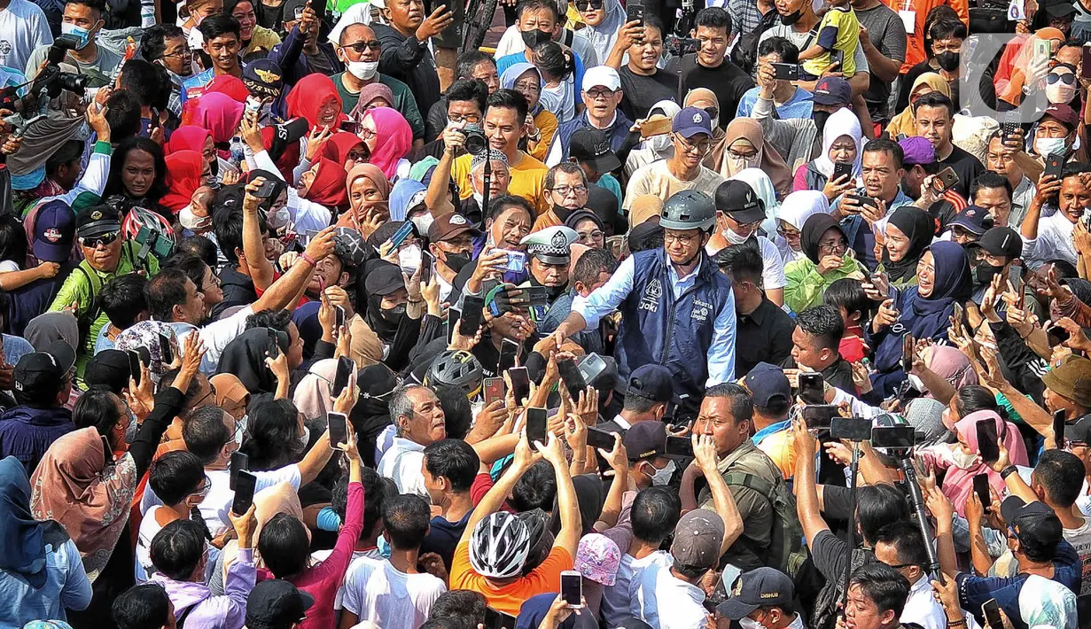 Gubernur DKI Jakarta Anies Baswedan menyapa warga yang tengah melakukan CFD di Bundaran HI, Jakarta, Minggu (16/10/2022). Anies berkeliling menggunakan sepeda menuju Balai Kota sambil menyapa warga Jakarta di hari terakhirnya menjabat sebagai DKI 1. (Liputan6.com/Angga Yuniar)