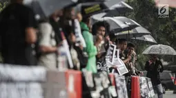 Aktivis Jaringan Solidaritas Korban untuk Keadilan (JSKK) saat menggelar aksi Kamisan ke-575 di depan Istana Merdeka, Jakarta, Kamis (21/2). Aktivis menolak kembalinya militer untuk menduduki jabatan sipil. (Liputan6.com/FaizalFanani)