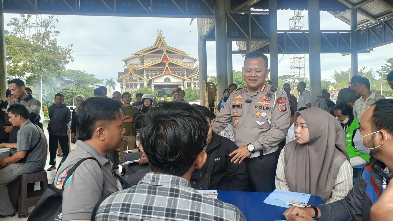 Direktur Lalu Lintas Polda Riau Komisaris Besar Taufiq Lukman Nurhidayat berbincang dengan masyarakat yang sedang melakukan perpanjangan SIM.