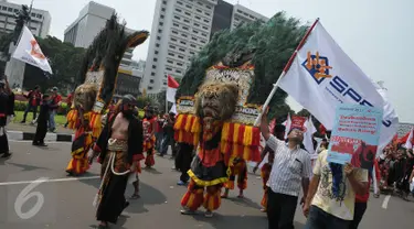 Massa aksi Hari Buruh Internasional membawa reog saat long march dari Tugu Tani ke depan Istana Merdeka hingga ke Monas, Jakarta, Senin (1/5) Dalam aksinya para buruh meminta sistem kerja kontrak dan upah rendah dihapus. (Liputan6.com/Helmi Afandi)