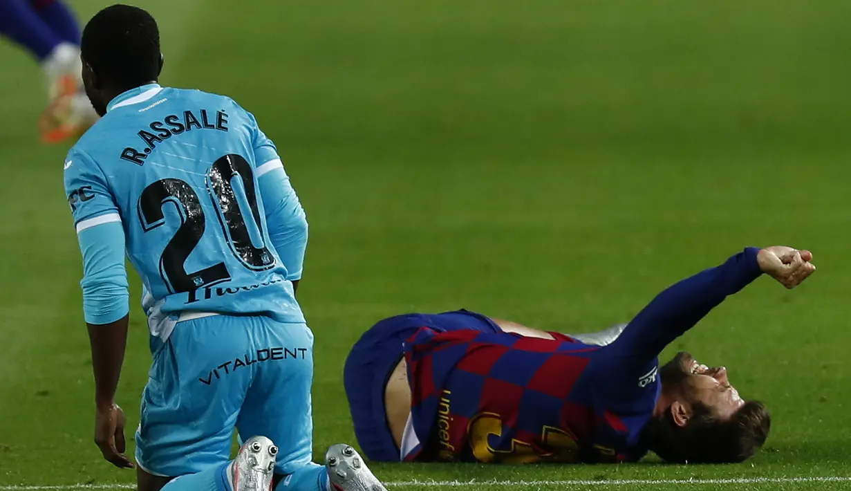 Pemain Barcelona Gerard Pique meringis kesakitan saat bertanding melawan Leganes pada pertandingan La Liga Spanyol di Camp Nou, Barcelona, Spanyol, Selasa (16/6/2020). Barcelona menang 2-0 lewat gol Ansu Fati dan Lionel Messi. (AP Photo/Joan Montfort)