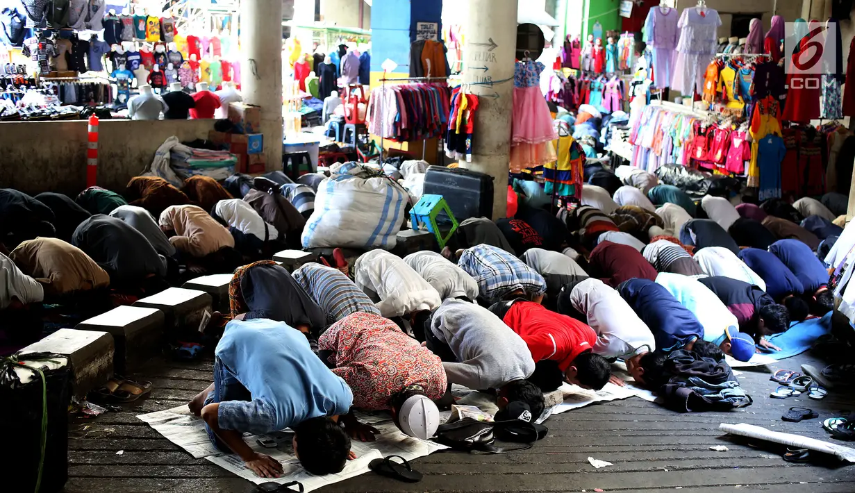 Umat muslim melakukan salat Jumat diantara kios-kios Pedagang Tanah Abang, Jakarta, Jumat (9/6). Dikarenakan membeludaknya jamaah yang ingin beribadah mereka terpaksa melakukan salat di antara kios-kios pasar. (Liputan6.com/Johan Tallo)