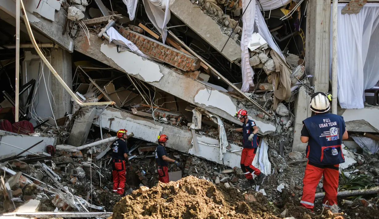 Anggota dari Pemadam Kebakaran Darurat Internasional Prancis mencari korban gempa dan tsunami di Palu, Sulteng (4/10). Lebih dari 2.500 terluka setelah gempa besar pada 28 September di daerah tersebut. (AFP Photo/Mohd Rasfan)