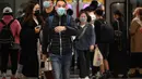 Orang-orang memakai masker di sistem Mass Transit Railway (MTR) di Hong Kong pada 27 Februari 2023. Langkah perpanjangan mandat masker dilakukan di tengah upaya pemerintah untuk menarik wisatawan dan pekerja asing untuk membantu menghidupkan kembali ekonomi negara itu yang terpuruk. (AFP/Peter Parks)