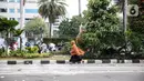 Seorang perempuan berlari di tengah massa pendemo yang terlibat bentrok dengan polisi di kawasan Patung Kuda, Jakarta, Selasa (13/10/2020). Perempuan yang terjebak itu diselamatkan pendemo saat unjuk rasa menolak Omnibus Law Undang-Undang Cipta Kerja tersebut ricuh. (Liputan6.com/Faizal Fanani)