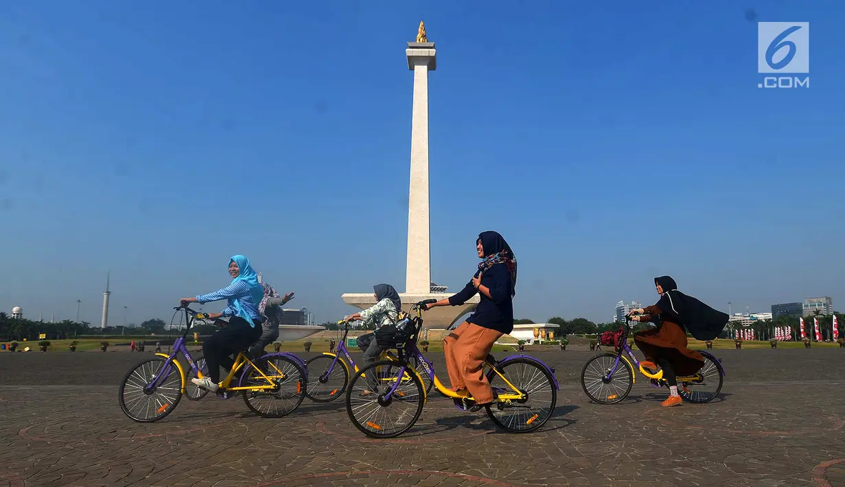 Pengunjung menggunakan sepeda dari layanan bike sharing di Monas, Jakarta, Jumat (27/7). Layanan ini merupakan kerja sama antara Smart City dan GOWES selaku operator bike sharing. (Merdeka.com/Imam Buhori)