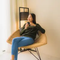 Seorang perempuan sedang menikmati secangkir kopi di sebuah kursi (Foto Dok: Freepik/lifeforstock).